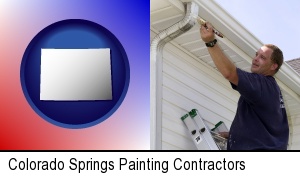 Colorado Springs, Colorado - a painting contractor brushing paint on an aluminum leader