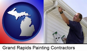 a painting contractor brushing paint on an aluminum leader in Grand Rapids, MI