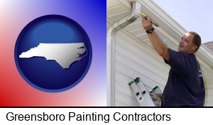 Greensboro, North Carolina - a painting contractor brushing paint on an aluminum leader