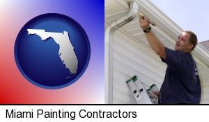 Miami, Florida - a painting contractor brushing paint on an aluminum leader