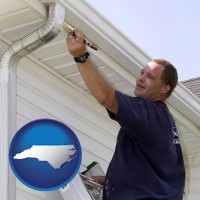 north-carolina map icon and a painting contractor brushing paint on an aluminum leader