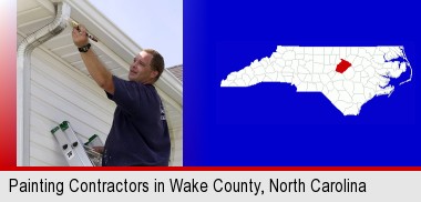 a painting contractor brushing paint on an aluminum leader; Wake County highlighted in red on a map